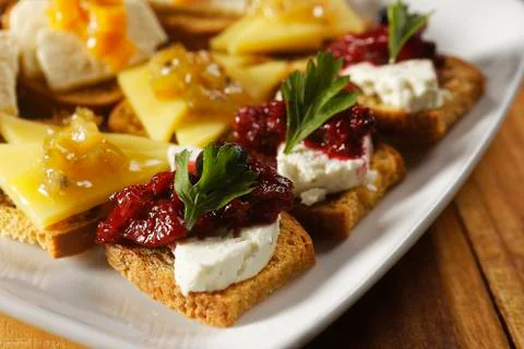 Snacks of toasted bread with Mozarella cheese, fresh cheese and Manchego chee Stock Photos