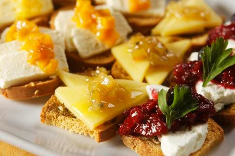 Snacks of toasted bread with Mozarella cheese, fresh cheese and Manchego chee Stock Photos