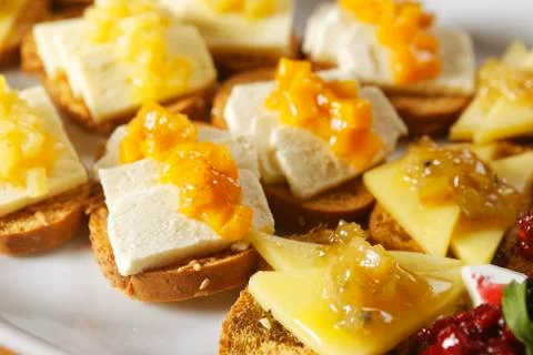 Snacks of toasted bread with Mozarella cheese, fresh cheese and Manchego chee Stock Photos