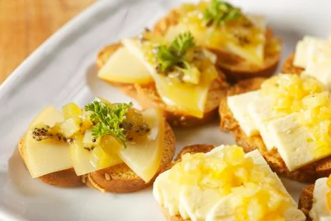 Snacks of toasted bread with Mozarella cheese, fresh cheese and Manchego chee Stock Photos