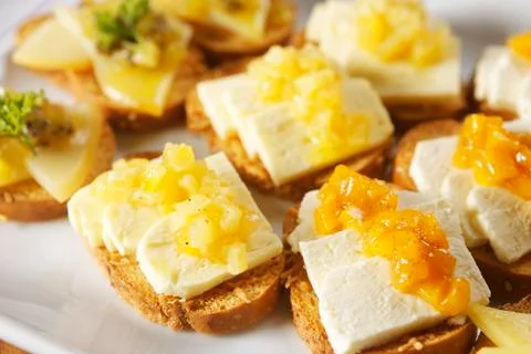 Snacks of toasted bread with Mozarella cheese, fresh cheese and Manchego chee Stock Photos
