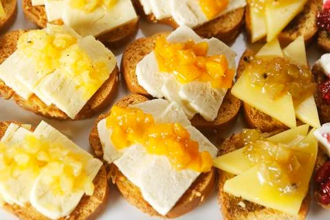 Snacks of toasted bread with Mozarella cheese, fresh cheese and Manchego chee Stock Photos