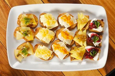 Snacks of toasted bread with Mozarella cheese, fresh cheese and Manchego chee Stock Photos