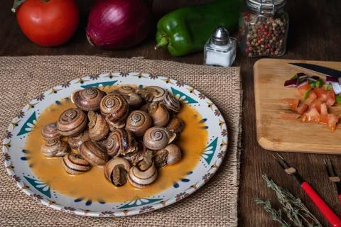 Snail stew, dish based on a sauce of vegetables and cooked snails. Stock Photos