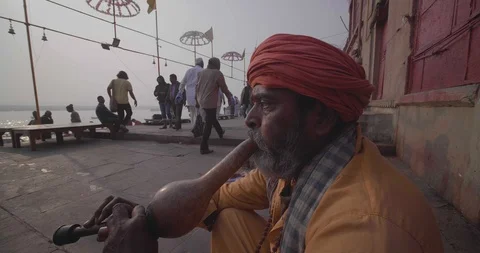 Snake charmer playing flute to charm snakes and begging money Varanasi Stock Footage 125229463