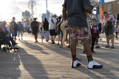 Snake handler on a crowded boardwalk Photos