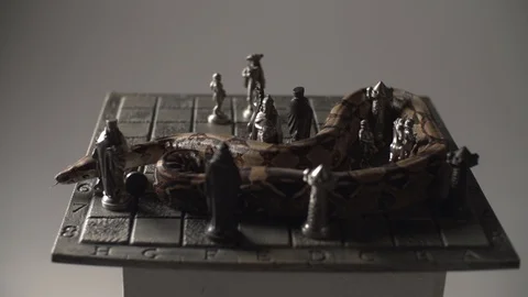 Snake Python crawling on vintage iron chess board. Studio white background Stock Footage 101866313