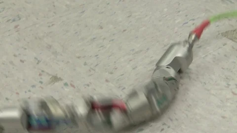 Snake-like robot machine crawling on a floor Stock Footage 99052766