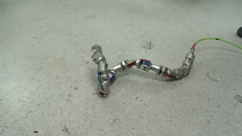 Snake-like robot machine on floor Stock Footage 99052717