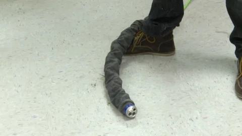 Snake-like robot machine moving on a floor Stock Footage 99052558
