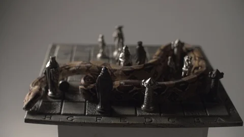 Snake on vintage chess board made of iron. Studio white background in slow Stock Footage 101866053