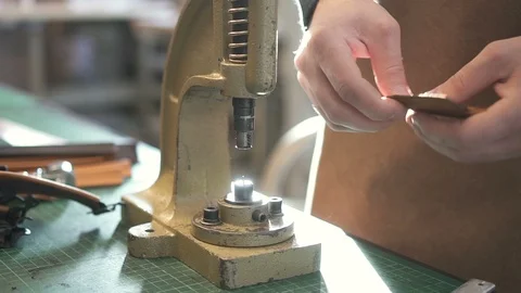 Snap buttons being fastened to artificial leather detail in workshop. Stock Footage 120409383