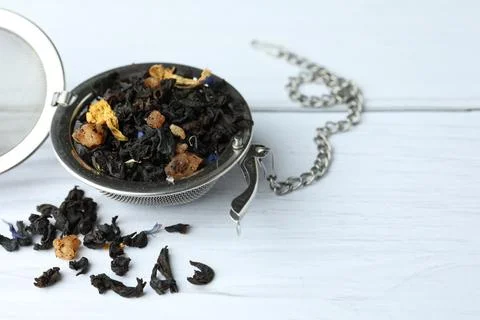Snap infuser with dried herbal tea leaves on white wooden table, closeup. Spa Stock Photos