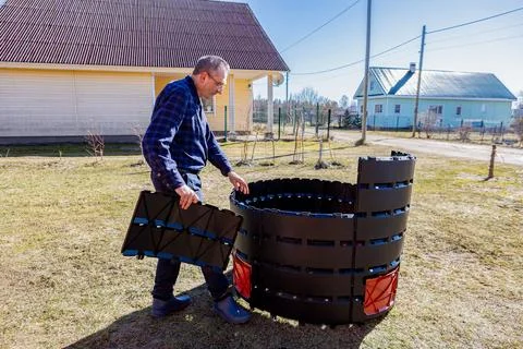 Snap together assembly modular compost bin, farmer installing mass produced.. Stock Photos