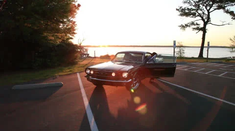Snap zoom to guy exiting Mustang, brilliant water sunset, 100% Video stock 23845986