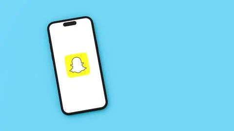 Snapchat Logo on Mobile Phone Screen on Flat Blue Background with Copy Space  Illustrazione stock