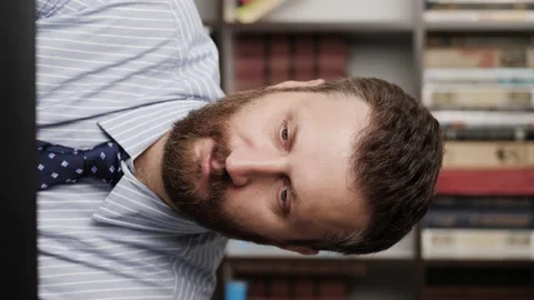 Snapping fingers. Vertical orientation of bearded man at workplace takes break Видео 132736139