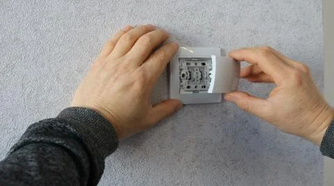 Snapping the plastic cover onto the wall switch housing Stock Photos