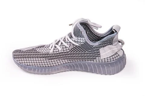 Sneaker against white background, featuring knit upper in gray and black, whi Stock Photos