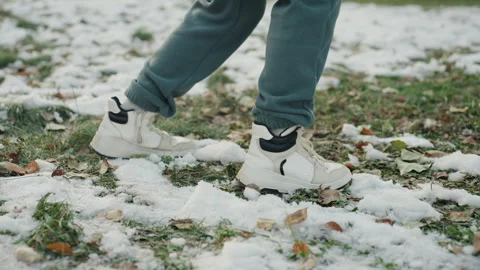 Sneaker pressing through frost. Silent prowler moves across icy grass. Tense Stock Footage 332043949
