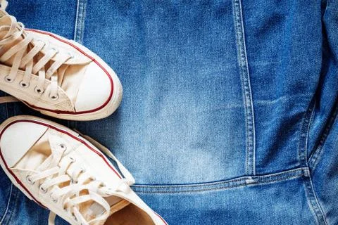 Sneakers on denim jacket. Stock Photos