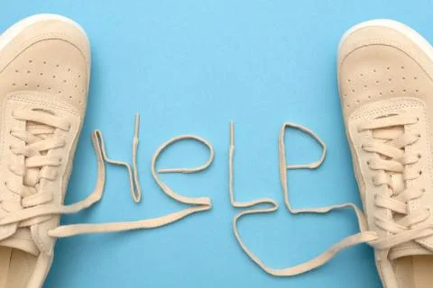 Sneakers with laces in help text. Support and service concept. Stock Photos