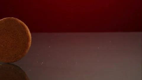 Snickerdoodle cookie rolling on red reflective surface Stock Footage 327051260