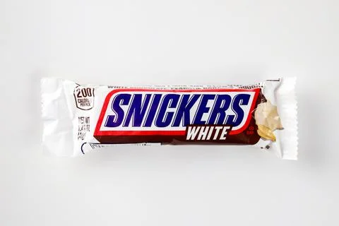 Snickers bar with fresh roasted peanuts, caramel and nougat covered in white Stock Photos