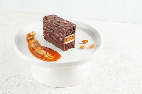Snickers cake. Dessert based on chocolate biscuit, creamy mousse with caramel Stock Photos