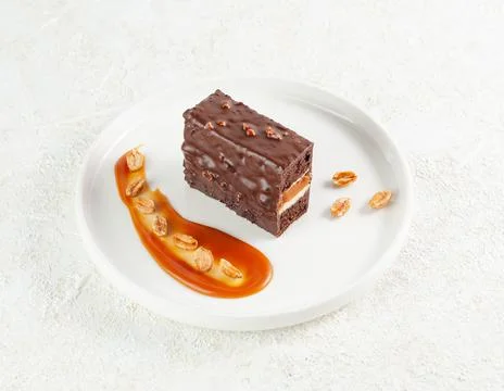 Snickers cake. Dessert based on chocolate biscuit, creamy mousse with caramel Stock Photos