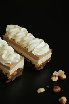 Snickers Layered Dessert Cake Slice with Nougat and Nuts on Black Background Stock-Fotos