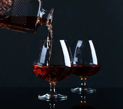 Snifter with brandy on a black background Stock Photos