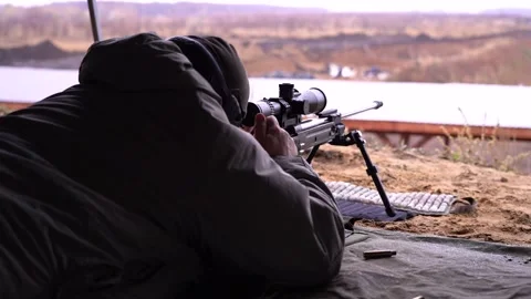 The sniper adjusts the sight, loads the rifle, takes aim and makes a shot Stock Footage 228053448
