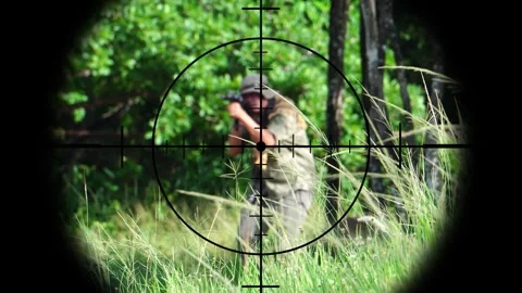 The sniper is aiming to kill the enemy through the scope Video stock 243199748