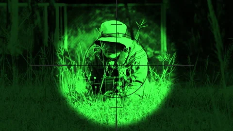 The sniper is aiming to kill the enemy through the scope nightvision Stock Footage 247704925