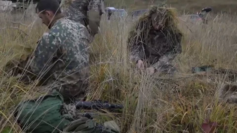 Snipers preparing ghillies suits with local elements Stock Footage 112159788