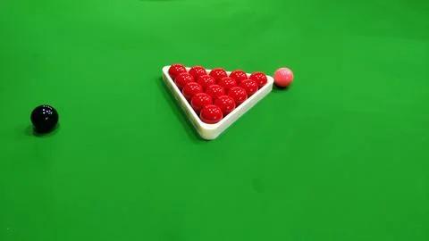 A snooker table with red balls in a triangle and a black and pink ball near Stock Photos