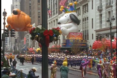 Snoopy and Garfield balloons float in the Macys Thanksgiving Day Parade. Stock Footage 552219