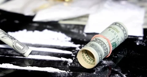 Snorting a line of cocaine with a rolled dollar bill, slow motion 動画素材 318493320