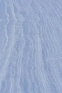 Snow after the wind forms a white canvas of swirling patterns. Light, sparkli 写真素材