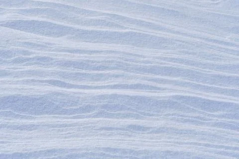 Snow after the wind forms a white canvas of swirling patterns. Light, sparkli Foto stock