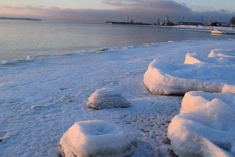 Snow and ice formations on Baltic shoreline at sunset Stock Photos