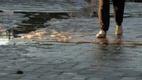 Snow and puddles on the tile on which a person walks Stock Footage 227571102