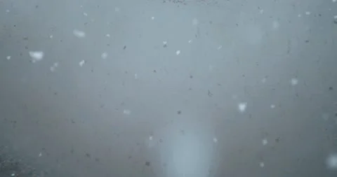 Snow and rain in a puddle through which a car is passing Stock Footage 143752411