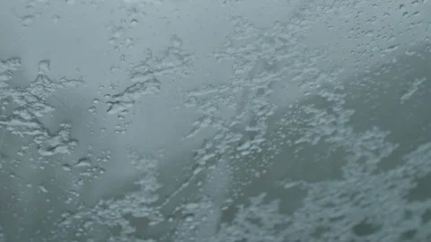 Snow and sleet sliding down foggy window Stock Footage 98439246