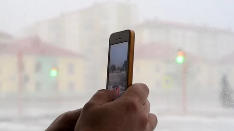 Snow and wind in the city in the spring afternoon on the background of houses an Stock-Footage 108849614