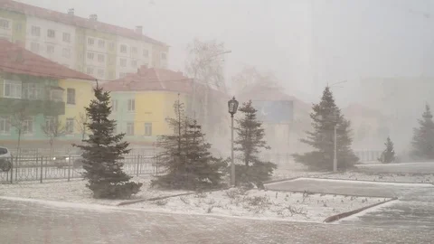 Snow and wind in the city in the spring afternoon on the background of houses an Stock-Footage 108849620