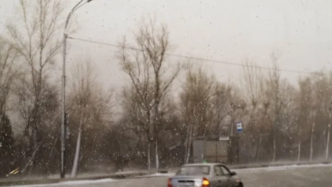 Snow and wind in the city in the spring afternoon on the background of houses an Stock Footage 111499668