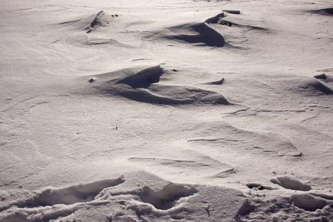 Snow and wind combined formed snow waves in a agricultural environment. Stock Photos