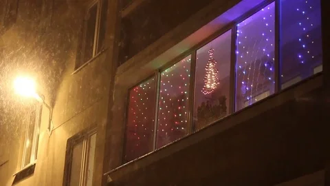 Snow on the background of Christmas decorations in the window Stock Footage 82250126